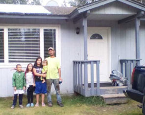 family standing next to home in alaska