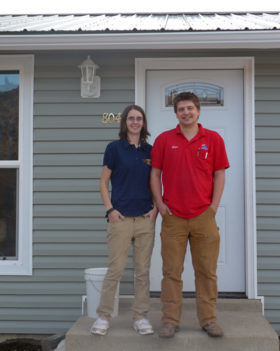 family standing in front of their house